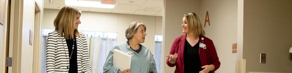 A nurse walks with two nurse administrators who received a Master of Nursing.