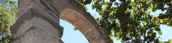 的 legendary NWU arch juxtaposed by green trees and blue sky. 